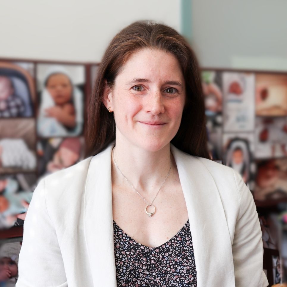 Dr Genevieve Genest in front of photos of babies her patients have delivered.